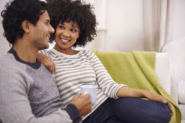 Casal relaxando no sofá de casa